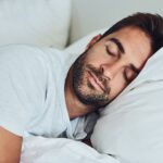 A peaceful person sleeping deeply, representing the health benefits of restorative sleep and wellness.
