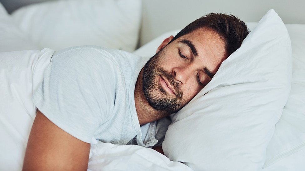 The Science of Sleep: Why Deep Rest is the Pillar of Long-Term Health A peaceful person sleeping deeply, representing the health benefits of restorative sleep and wellness.